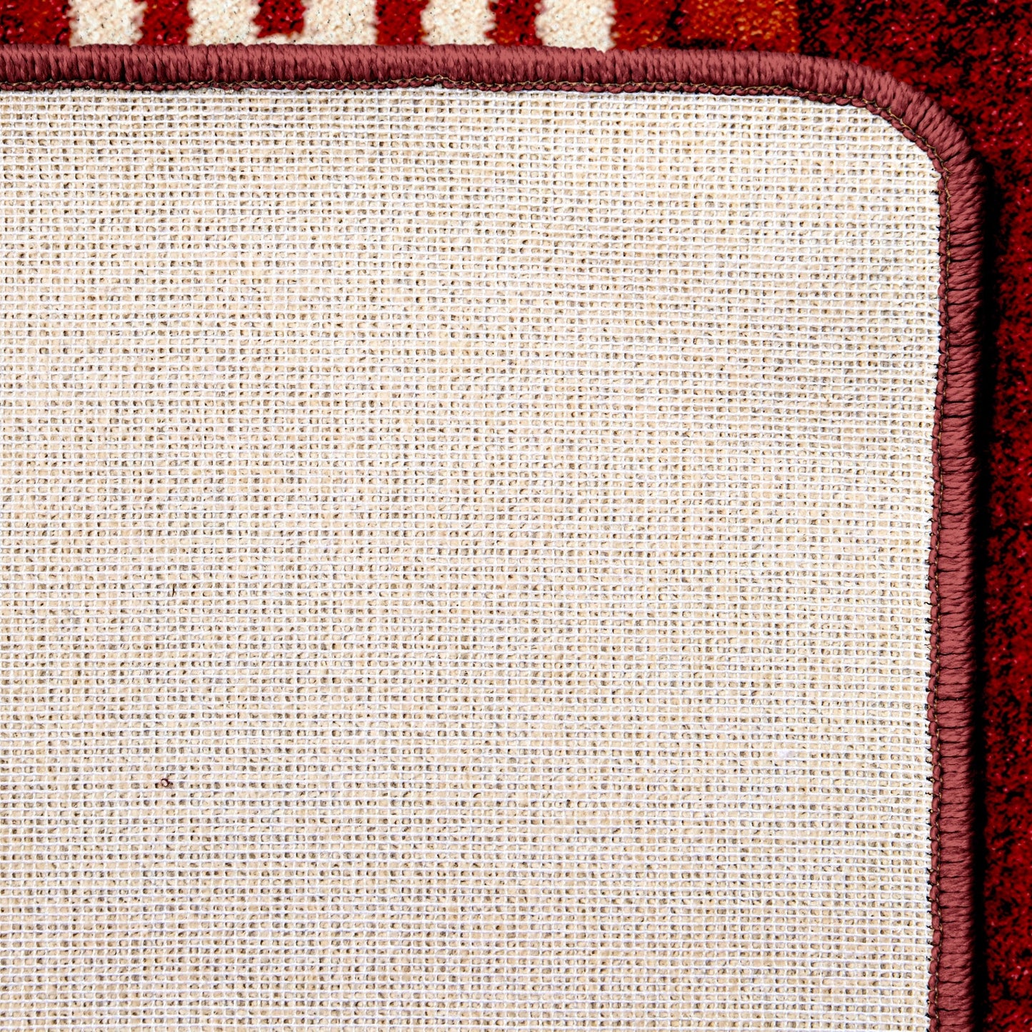 Close-up of a textured rug corner with a red border
