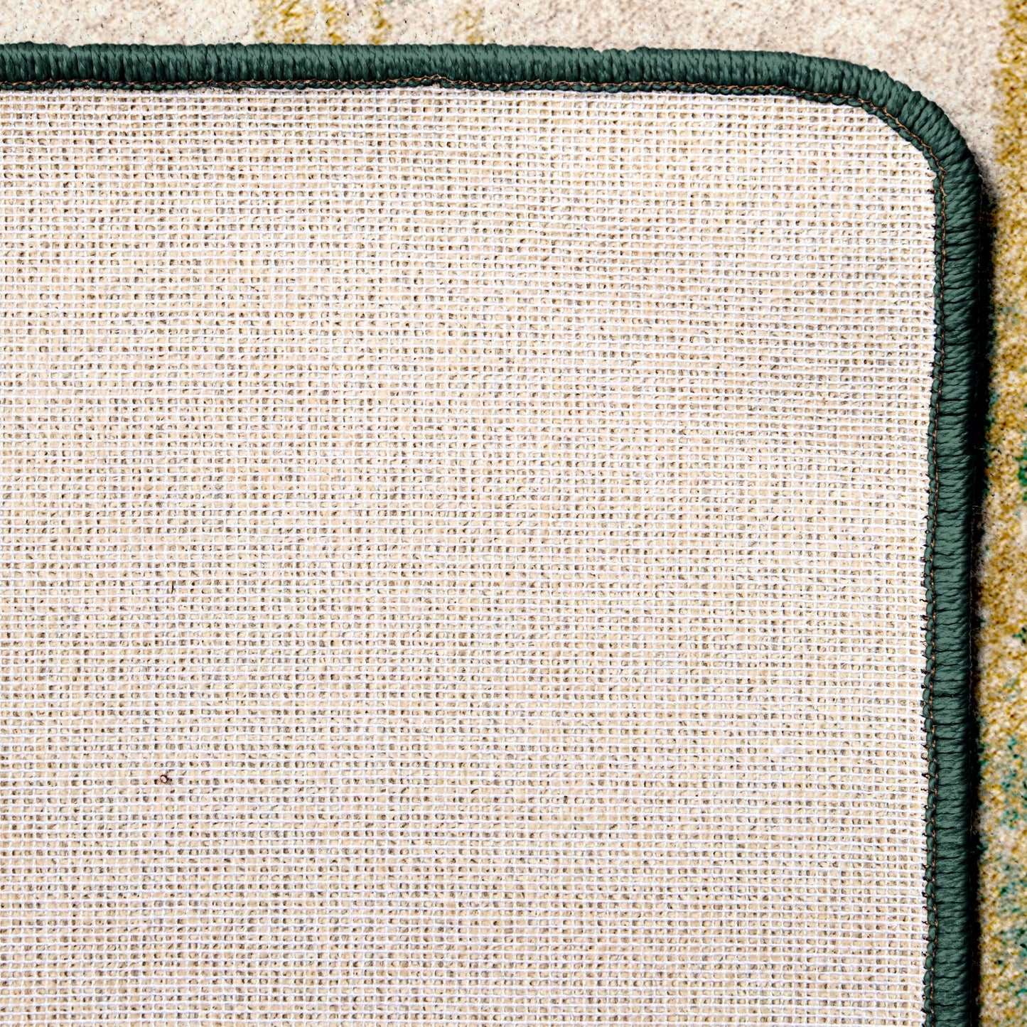 Close-up of a textured rug back corner with a green border